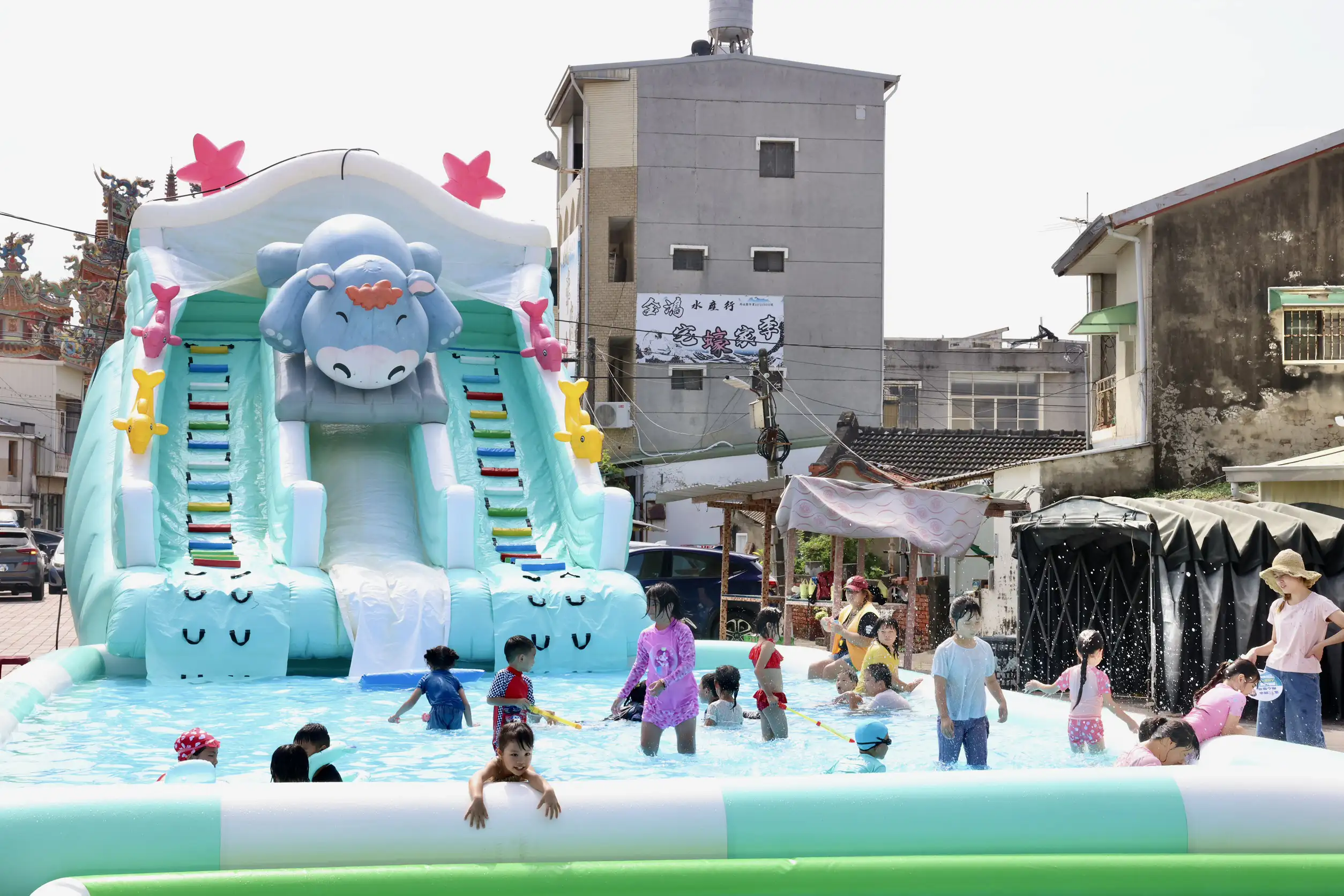 四鯤鯓紅樹林水上市集設置大型「鯤寶水樂園」氣墊戲水設施，小朋友開心挑戰大型滑水道，吸引親子家庭戲水消暑增添夏日熱鬧氣氛。（記者劉美祺攝）