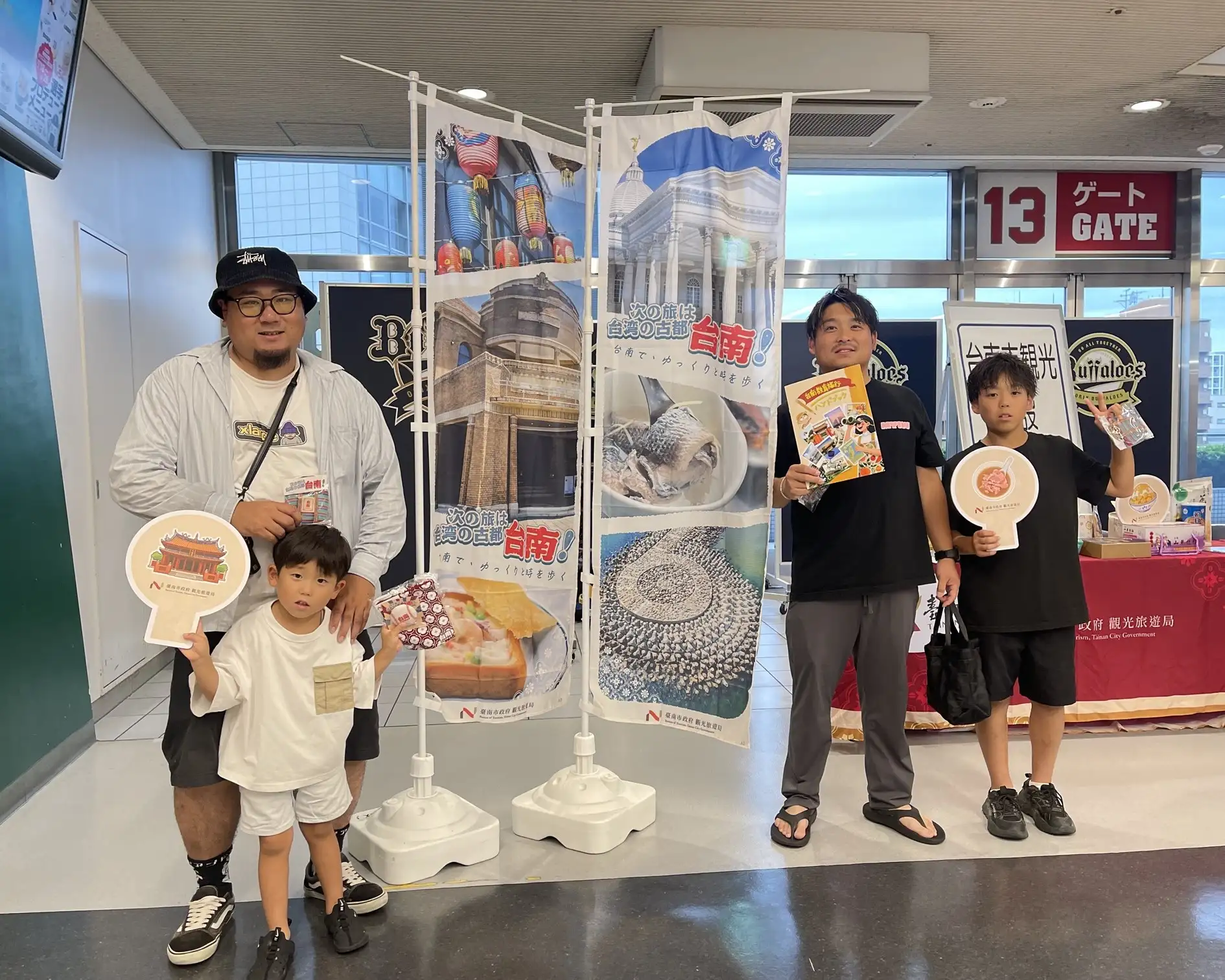 日本親子球迷與臺南觀光文宣開心合影。(台南市政府觀光旅遊局提供)