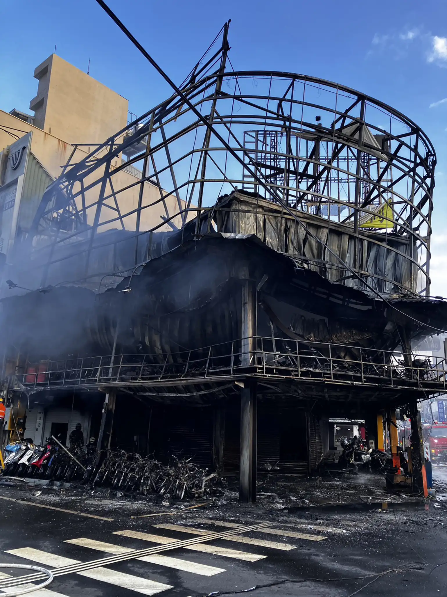 台南市中西區健康路一段機車行發生大火，火勢撲滅後現場滿目瘡痍，多輛機車遭燒成焦黑骨架，建物外牆及招牌結構也嚴重受損。(台南市消防局提供)