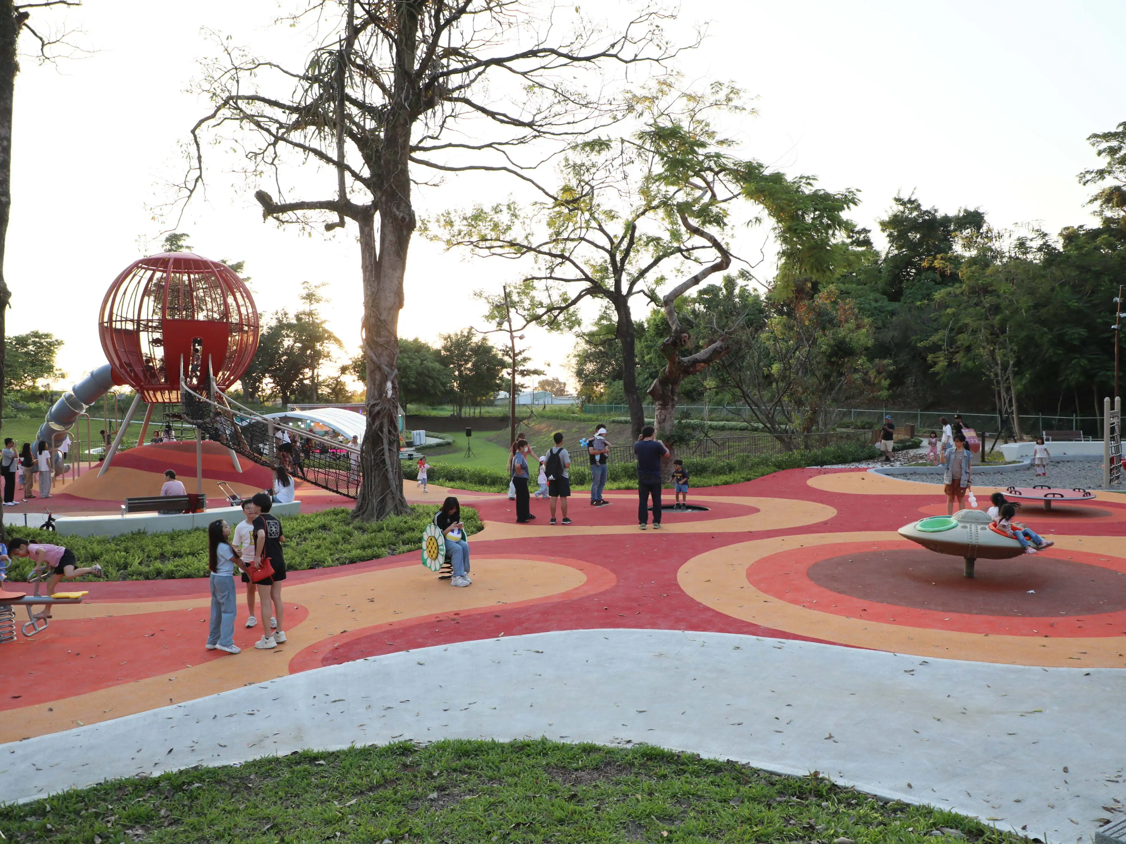 嘉義縣「共好公園」活化昔日閒置園區，打造全齡共享遊憩空間，其中大樹遊戲場設置大型攀爬設施及特色遊具，吸引親子前來體驗。（嘉義縣政府提供）