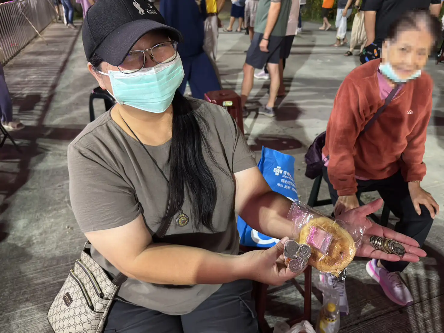 醉八仙大撒發財金讓信眾滿載而歸，民眾攤開手掌展示撿到的一疊零錢，笑著分享安座盛典的喜氣與福氣。(記者劉美祺攝)