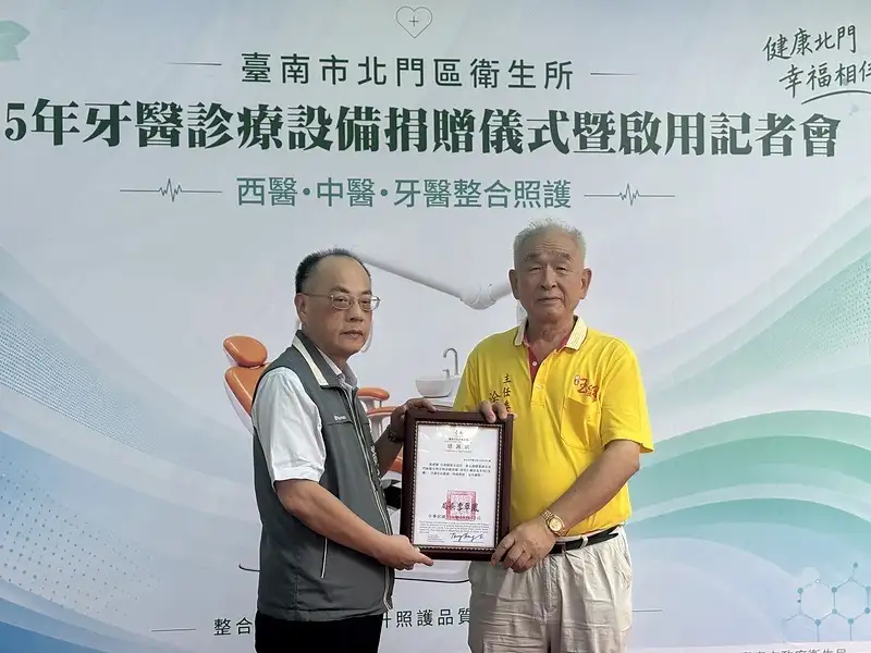 臺南市政府衛生局副局長黃文正（左）致贈感謝狀予臺南開基玉皇宮主委凃大松（右），感謝捐贈牙科治療椅及牙科X光機，支持偏鄉口腔照護。（圖/記者范繼如攝）