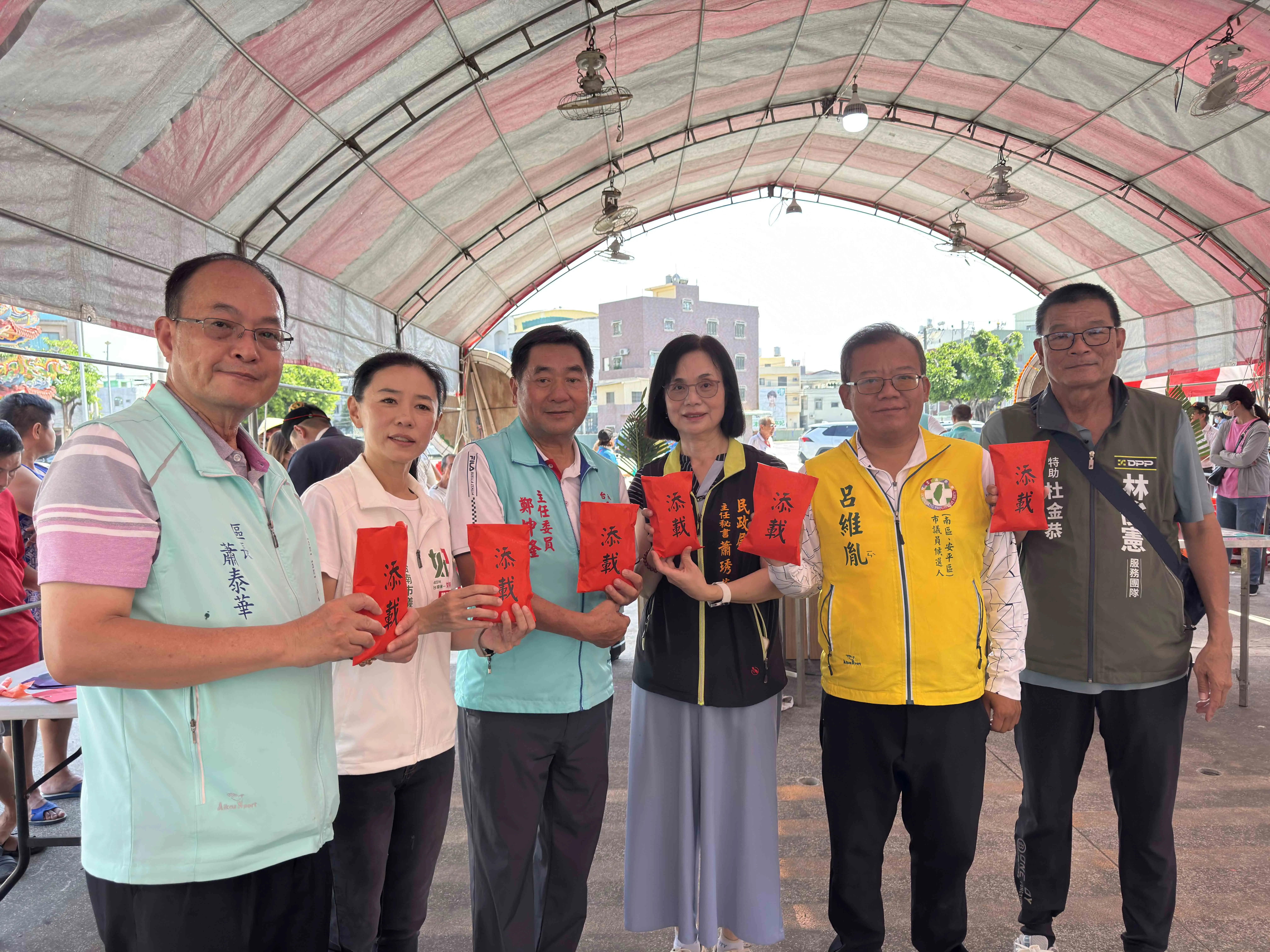 萬皇宮主委鄭坤隆與地方來賓手持「添載」物資，共同為萬皇仙舟添載，延續喜樹龜醮百年傳統，祈願庄頭平安順遂。（記者劉美祺攝）
