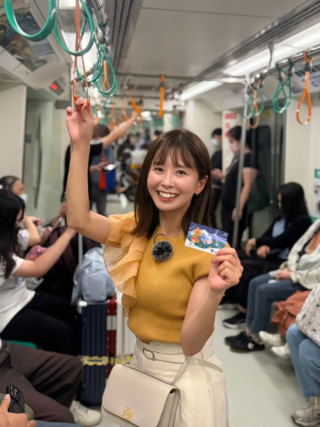 日本人氣女主持人渡部有搭乘高雄捷運，手持MeNGo交通卡體驗港都便捷的大眾運輸，帶領日本觀眾感受高雄自由行的便利與城市魅力。（高雄市新聞局提供）