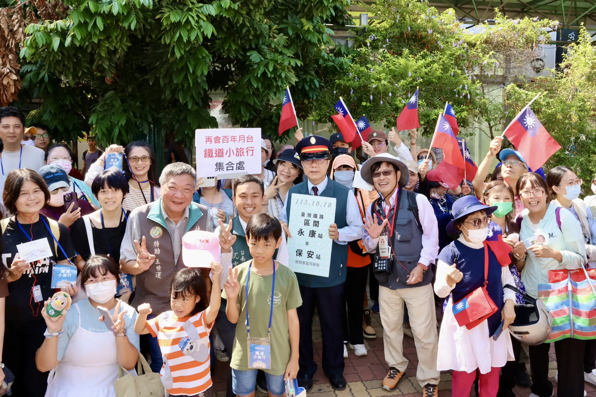 台南市長黃偉哲化身「一日站長」，與參加鐵道小旅行的大小朋友開心合影，眾人揮舞國旗，共同迎接台南鐵路地下化第一階段通車的重要時刻。（台南市政府提供）