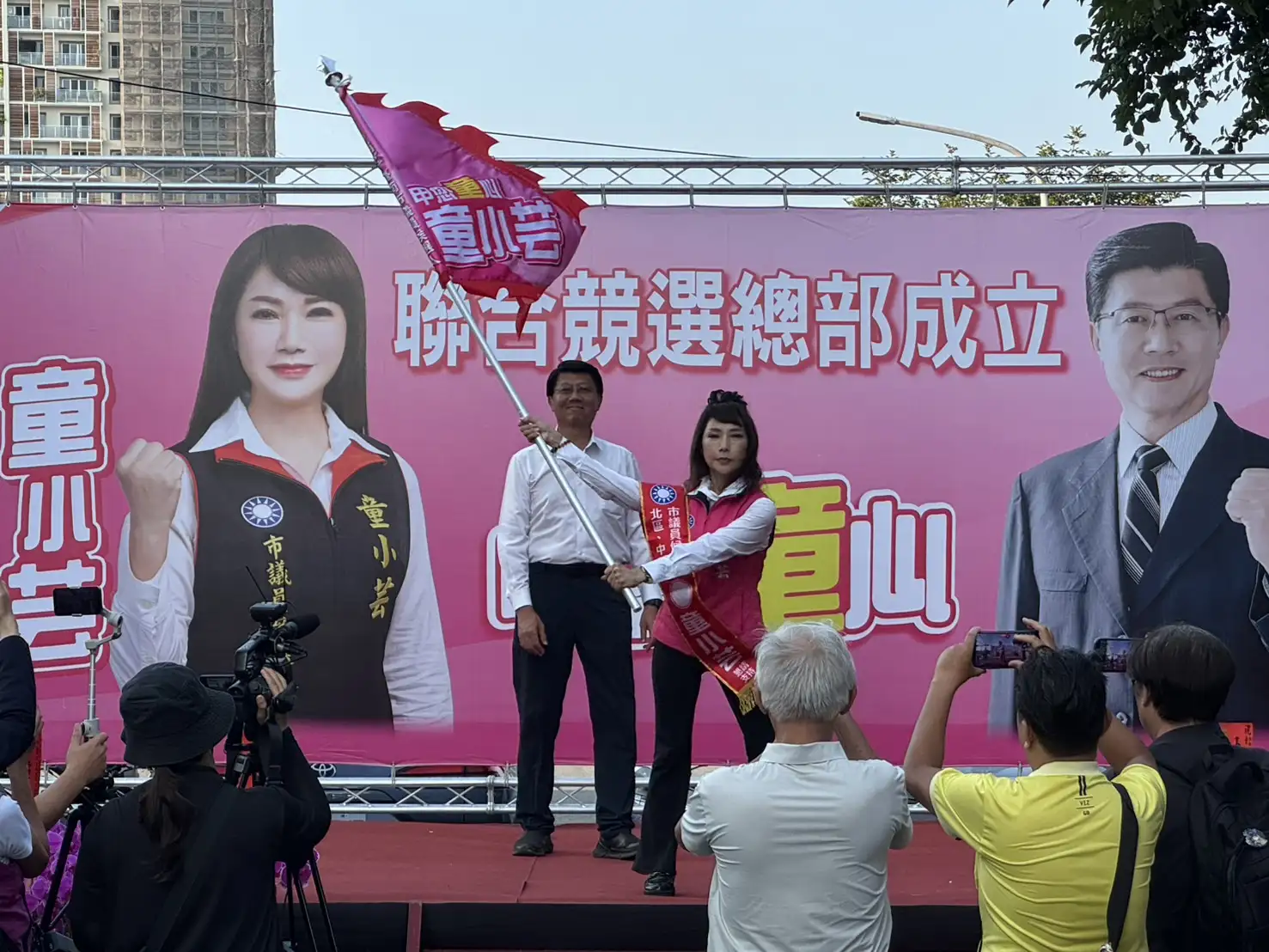 國民黨台南市長參選人謝龍介（左）在聯合競選總部成立大會中，授予市議員參選人童小芸（右）競選戰旗，象徵選戰正式啟動，力拚中西北區議員第三席。（記者張振興攝）