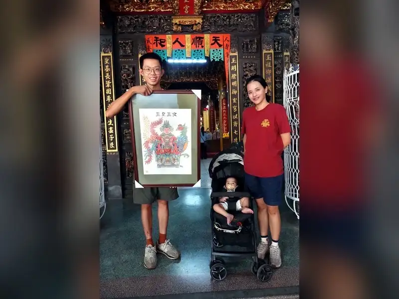素人畫家劉峻宏與妻兒到開基玉皇宮獻上親繪的「玉皇玉女」畫作，感謝三公主娘庇佑。（圖／記者范繼如攝）