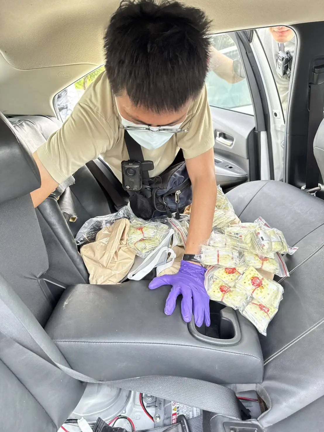 臺南市少年警察隊專案人員搜查涉案白色權利車，當場自車內後座夾層中起獲大量分裝捆綁之毒品咖啡包。(圖 / 張振興翻攝)