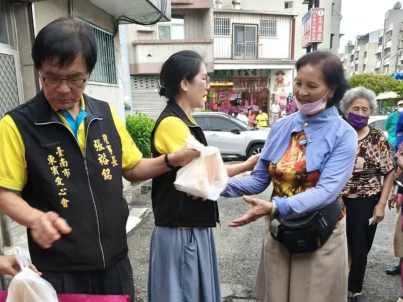 東賓愛心會理事長張裕銘將愛心便當交到民眾手中，透過每月固定供餐，傳遞社區溫暖。（圖/記者范繼如攝）
