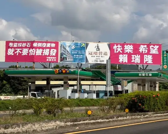 高雄市議員鍾易仲29日指出，國道10號旗山端原本批評柯志恩刪減高雄預算的看板，近日再度換回「快樂希望賴瑞隆」形象文宣，質疑相關宣傳內容反覆更動，並要求釐清高雄預算爭議。（鍾易仲提供）
