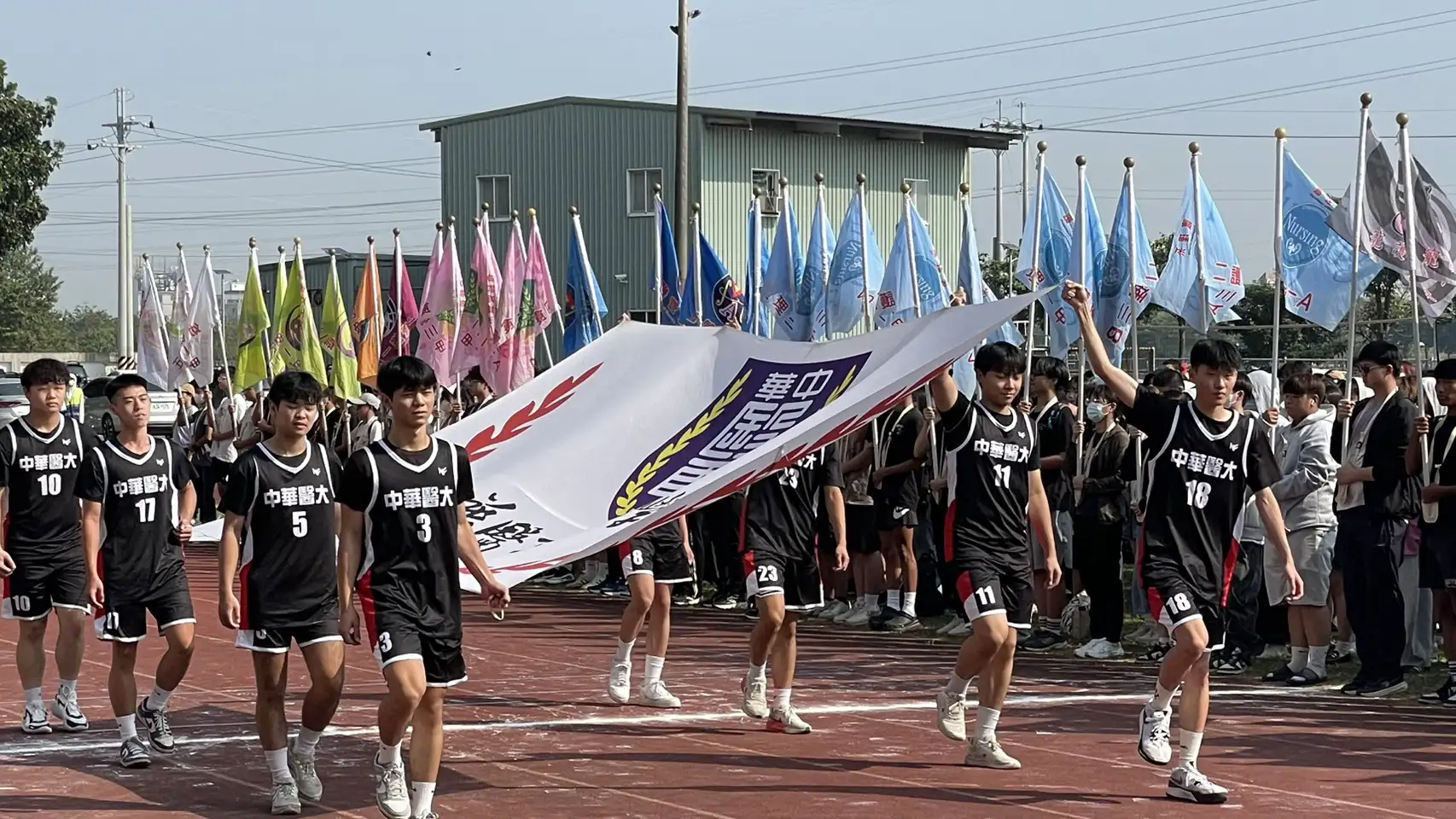 中華醫大歡慶創校58週年，校慶運動會熱鬧登場，由籃球校隊選手護送校旗進場，為活動揭開序幕。(中華醫大提供)