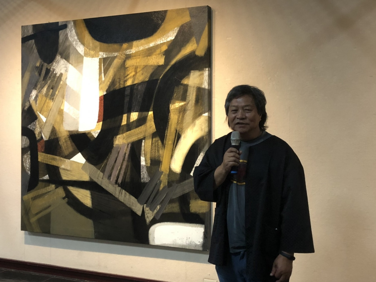 鄭宏章與展出畫作之一「穿林」，以金黃色調，象徵穿越森林看見樹上灑下的陽光，充滿生命力。