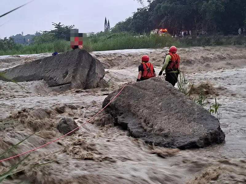 嘉義縣男子釣魚遇溪水暴漲受困於溪水中間險象環生，警消人員獲報後前往渡河救援。（圖/嘉義縣消防局提供）