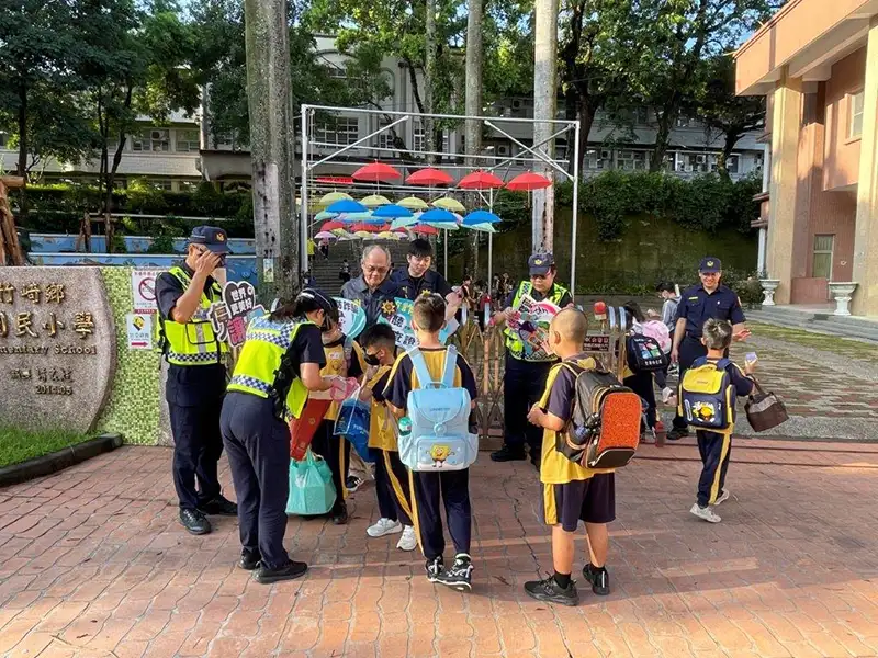 竹崎分局在校門口協助人車疏導，並發送精美宣導小物，以確保校園和交通安全。(記者張振興翻攝)