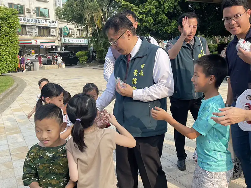 台南市長黃偉哲也到場發送糖果給小朋友，被孩子們團團圍住。(圖/台南市政府  提供)