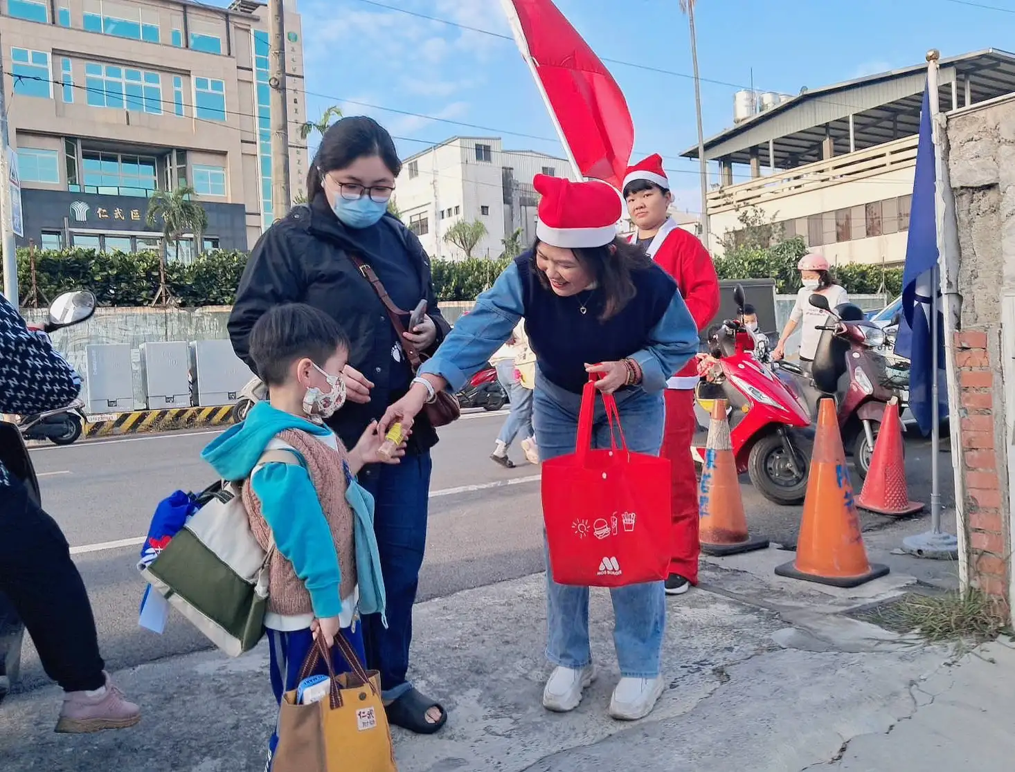 前市議員陳若翠扮聖誕老人 揮舞國旗慶祝行憲紀念日，並快閃迎接下課的小朋友發送耶誕禮物。（記者吳文欽攝）