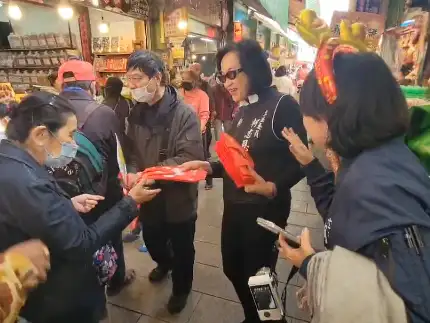 國民黨立委柯志恩在三鳳中街年貨大街開跑日，與高雄市議員黃香菽合體，拍攝新年賀歲短片，並沿路發放特製小福袋，祝福市民朋友新年快樂。（記者吳文欽攝）