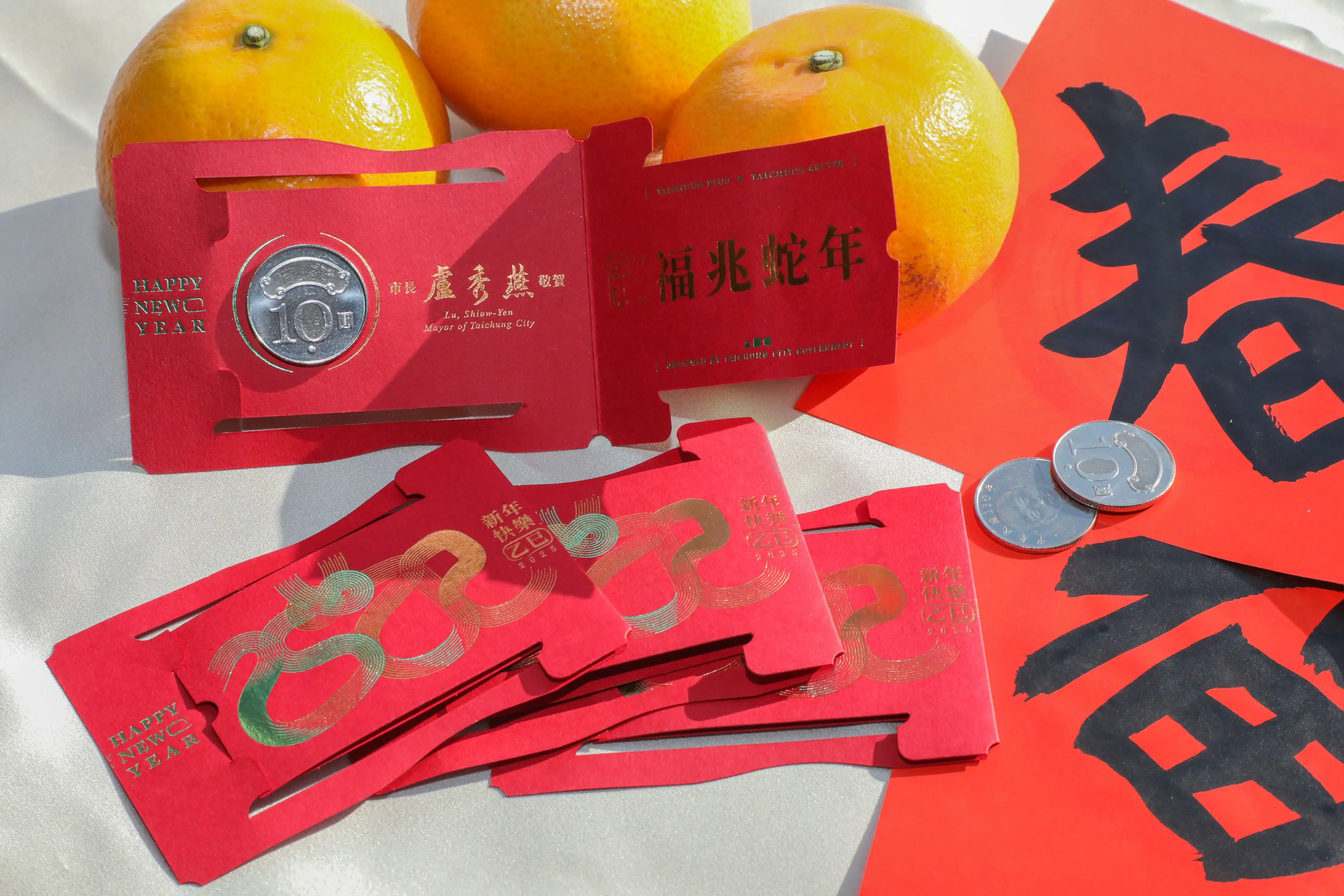 小紅包以平安蛻變為主題，紅包內附十元硬幣，並印有「福兆蛇年」燙金祝賀詞。(圖/台中市政府提供)