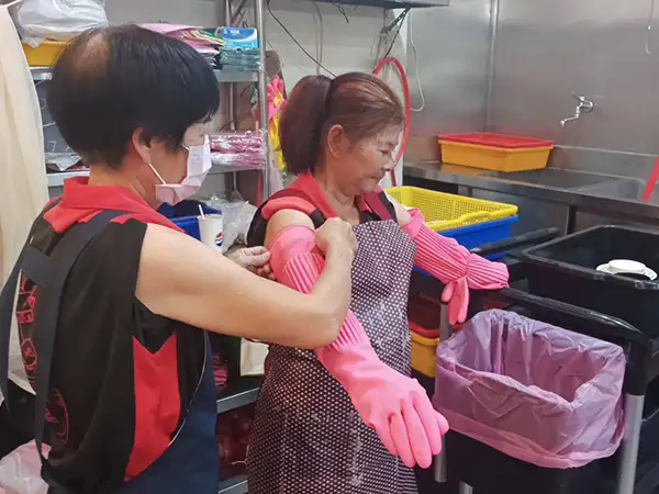 阿美在「鴻品牛肉湯」受到同事相互幫助，每天為她帶上餐具清潔手套