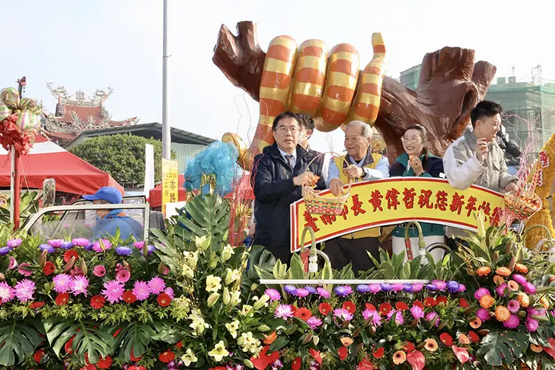 黃偉哲市長與來賓站在花車上揮手致意，後方巨型蛇形花燈裝飾展現「金蛇報喜」主題，象徵新年行大運的祝福。(圖/台南市政府提供)