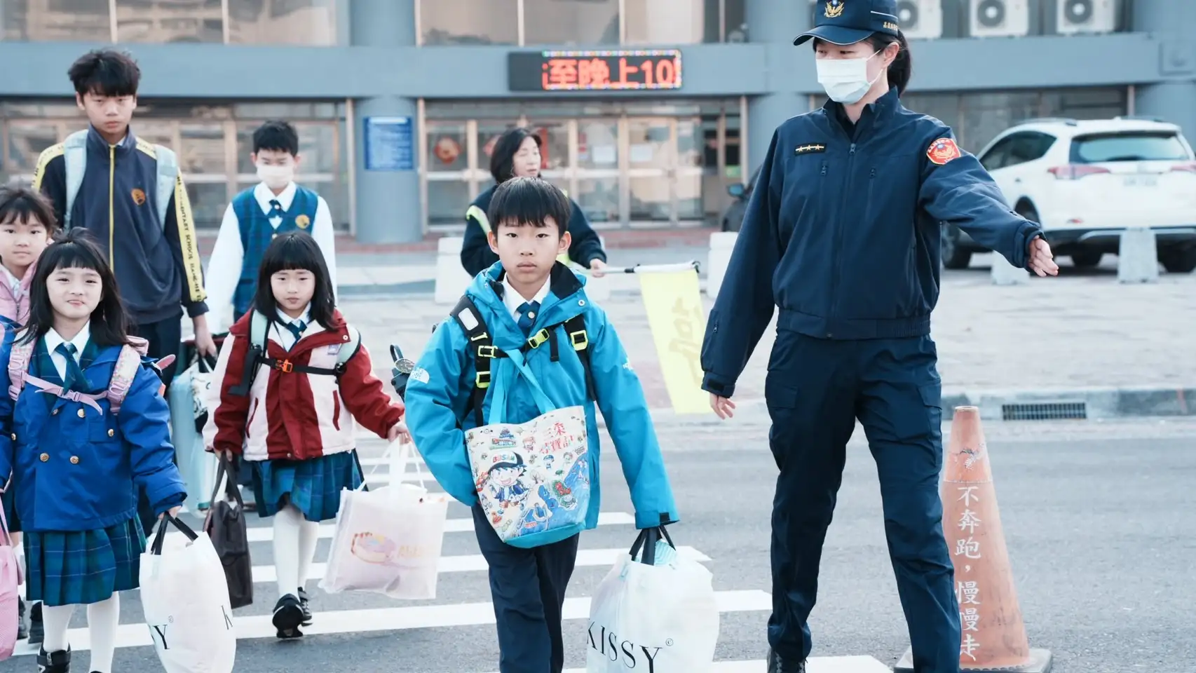 員警在校門口協助學童安全過馬路，確保學生上下學交通安全。(圖/嘉義縣警察局提供)