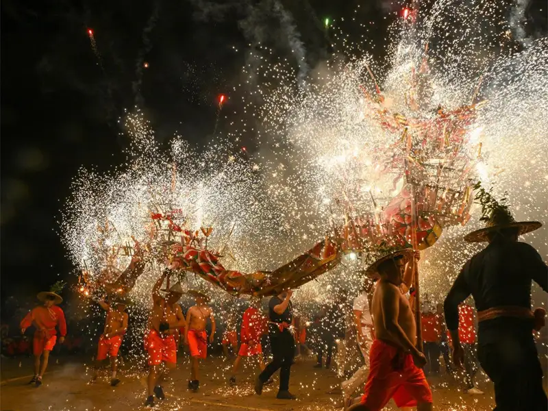 舞龍隊青年們舉著火龍，僅穿短褲赤膊上陣，靈活地繞場遊動。(記者楊婉攝)