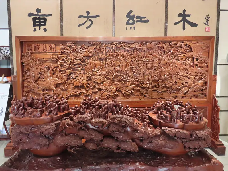 東方紅木館內作品《群仙祝壽》,前景以松林環繞、祥獸盤踞,百仙齊聚獻禮,細雕工細膩氣勢恢宏,展現東方傳統工藝與吉祥寓意的完美結合。(記者劉美祺攝)