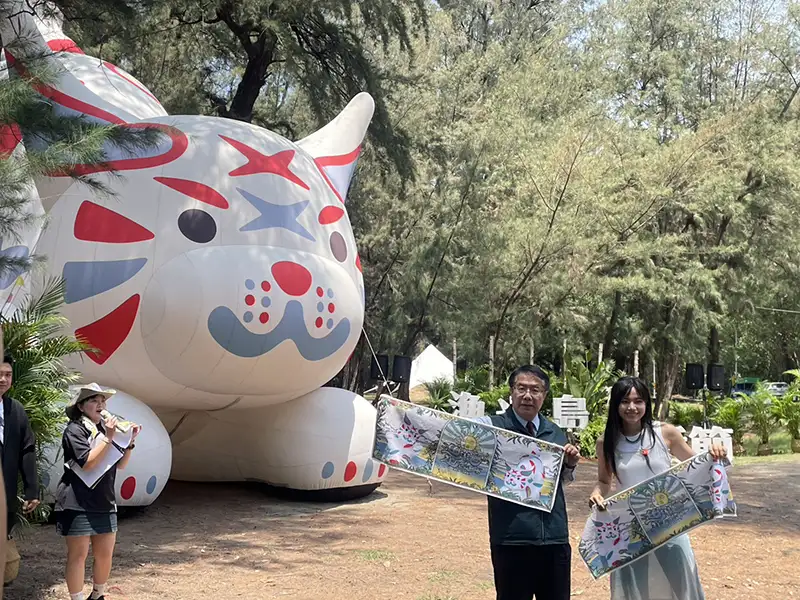 創作歌手吳汶芳(右)現身記者會為2025漁光島生活節站台,與市長黃偉哲(左)一同展示周邊商品,共同邀請民眾放慢腳步,體驗小島生活的自在與療癒。(圖/記者林怡孜攝)