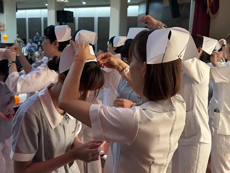 中華醫大護理系114年加冠典禮,學生接受老師佩戴護士帽,象徵正式踏入護理專業,傳承南丁格爾精神。(記者張振興攝)