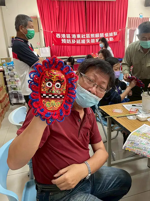 長輩開心秀出自己做的獨特獅面具。(圖/嘉南藥理大學 提供)