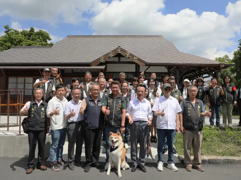 阿里山林鐵鹿麻產車站重新啟用,縣長翁章梁以及在地社區代表與實習站長秋田犬「波吉」共同合影,見證百年車站再現風華。(圖/嘉義縣政府提供)