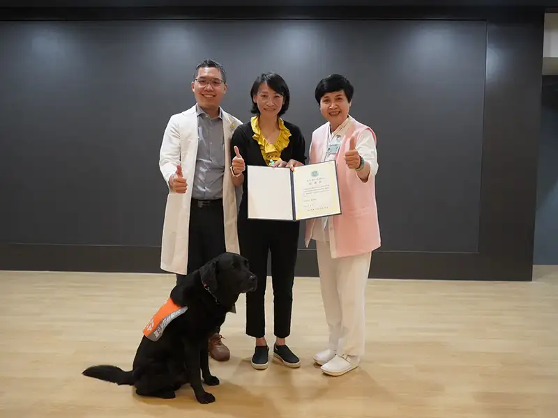 屏東榮總護理部主任徐敏芬(右)與家醫科劉星佑醫師(左)頒發感謝狀給劉曉菁老師(中)及輔助犬歐巴(下)。（圖/屏東榮總 提供）