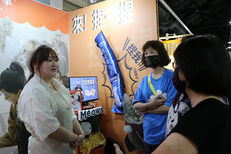 高鑀娳(左)於新一代設計展向民眾介紹畢業製作內容與推廣業主品牌。(圖/崑山科技大學 提供)