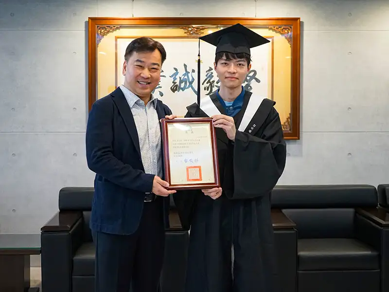 錢谷村(右)畢業之際獲校方頒發傑出專業榮譽獎,與李天祥校長(左)合影。(圖/崑山科技大學 提供)
