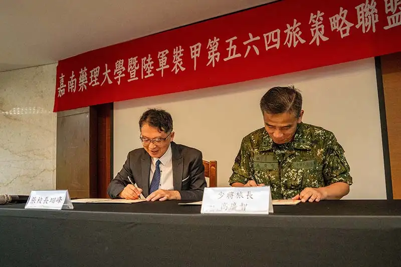 嘉藥張翊峰校長(左)與裝甲第五六四旅旅長高廣智將軍代表簽約。(圖/嘉南藥理大學 提供)