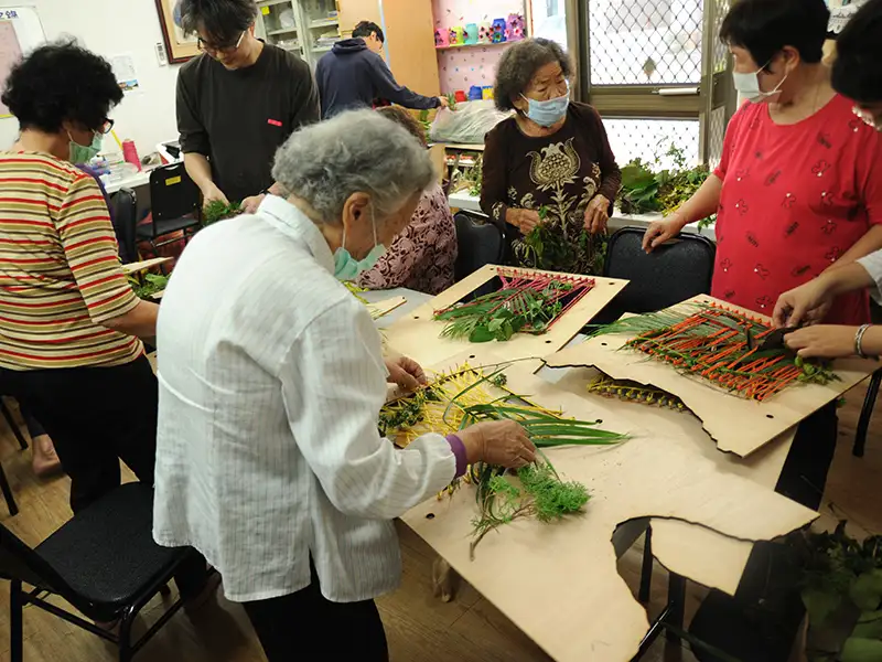 空設系與龍崎地區的耆老用植物進行編織。(圖/ 崑山科技大學 提供)