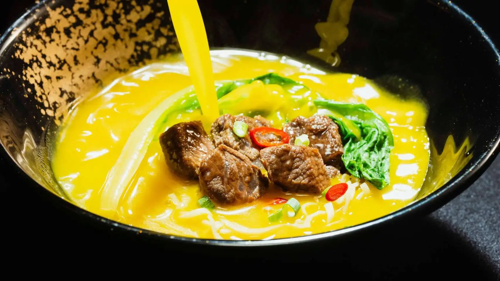 源自於川菜金湯肥牛的「金牛肉麵」,取其誘發食慾的黃金色澤湯頭。(圖/滿漢大餐 提供)