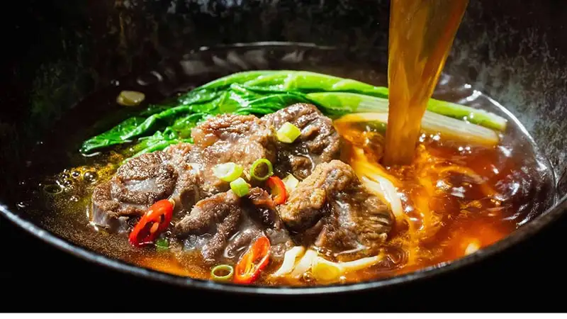 「熗牛肉麵」則致敬川菜經典「水煮牛」,麻辣鮮香兼具、香氣濃郁的川魂湯頭。(圖/滿漢大餐 提供)