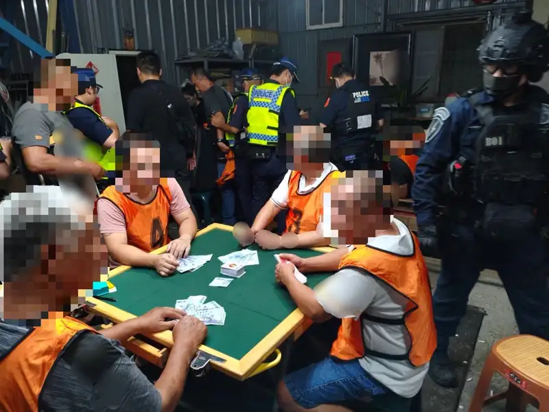 臺南市第三分局持搜索票進入安南區環福街鐵皮屋，查獲「妞妞紙牌」職業賭場，現場查獲22人即查扣賭資2萬3000元。(圖/第三分局提供)