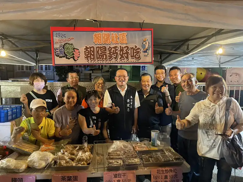 馬公市長黃健忠在朝陽社區攤位與社區居民合影互動,現場展售多款特色美食,氣氛熱絡。(圖/馬公市公所提供)