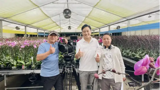 台灣知名演員李志希（中）在花卉基地拍攝現場與團隊合影。(記者劉美祺翻攝)