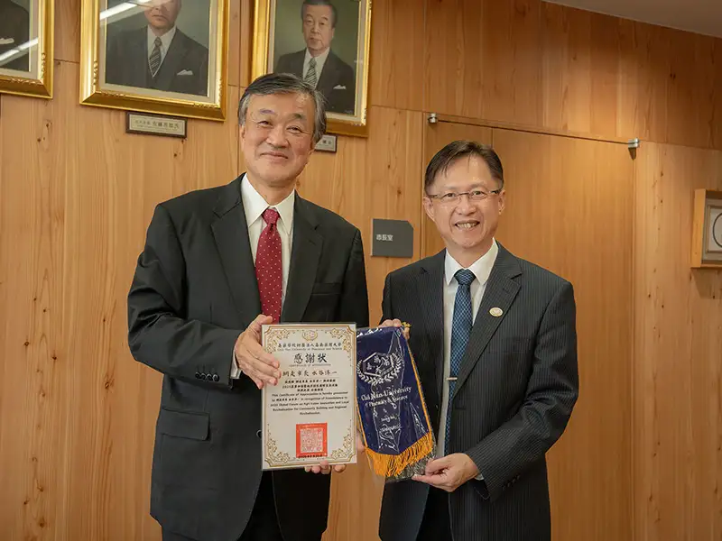 嘉藥主任秘書陳品晟(右)代表校方致贈禮品感謝北海道網走市市長水谷洋一接待。(圖/嘉南藥理大學 提供)