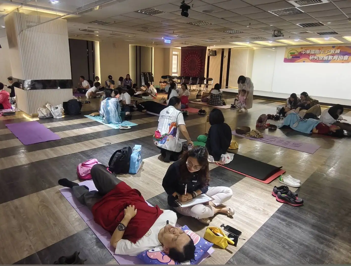 中華國際NLP教練研究發展教育協會舉辦「百人催眠公益體驗」，參與者在專業教練引導下，進行前世回溯催眠，引領潛意識探索與內在覺察，展開一段自我療癒之旅 (圖片來源/記者林怡孜攝)