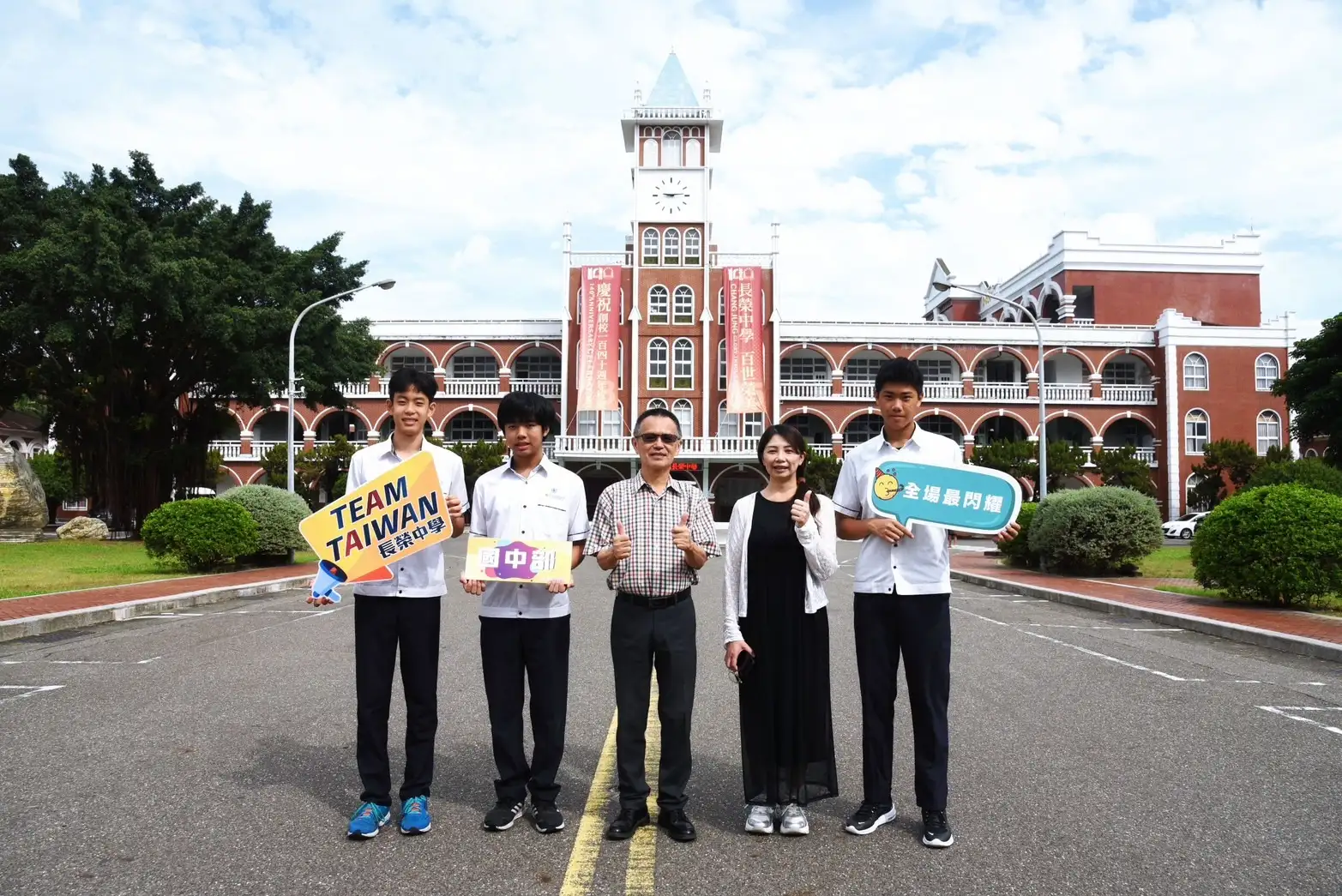 長榮中學國中部學生在多益測驗中表現亮眼：李品澔（右一）勇奪945分、周昱丞（左二）915分、謝允斌（左一）900分，展現超越同齡的國際語言力。三人亦為全國生物科展冠軍，兼具科學與語言實力。圖為三位同學與許德勝校長（中）、教務處陳淑萍主任（右二）於長榮中學鐘樓前合影。(圖/長榮中學 提供)]