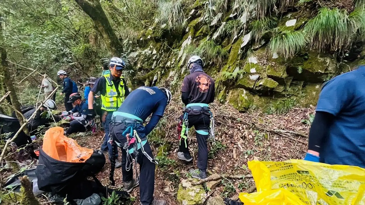 救難人員在嘉義縣阿里山石山引水道步道架設繩索垂降，合力救援墜入溪谷的11歲男童。(圖/竹崎分局提供)