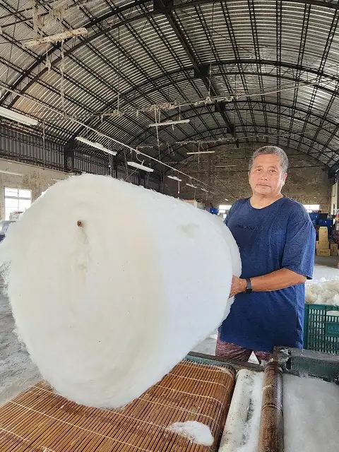 成團的棉花放進梳棉機會被梳理成一捲棉片,捆在竹竿上就像是巨大棉花糖。(圖/臺南市政府觀旅局 提供)