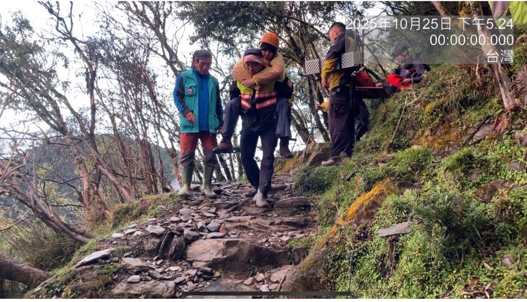 搜救人員冒雨上山救援,協力將高山症女子接力背負下山。(圖/竹崎分局 提供)