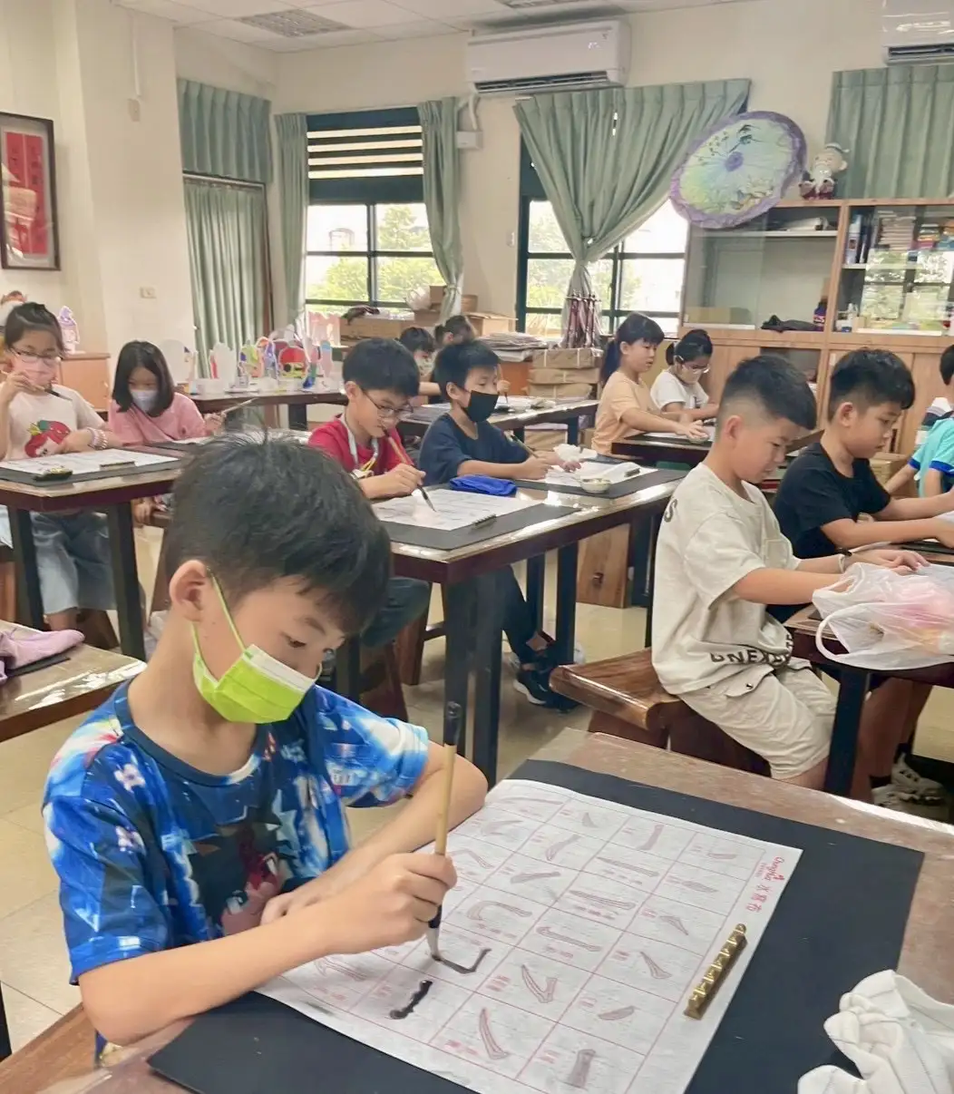 三年級小朋友跟著老師練筆，筆尖舞出文字之美，開啟書法探索之旅。（大寮國小提供）