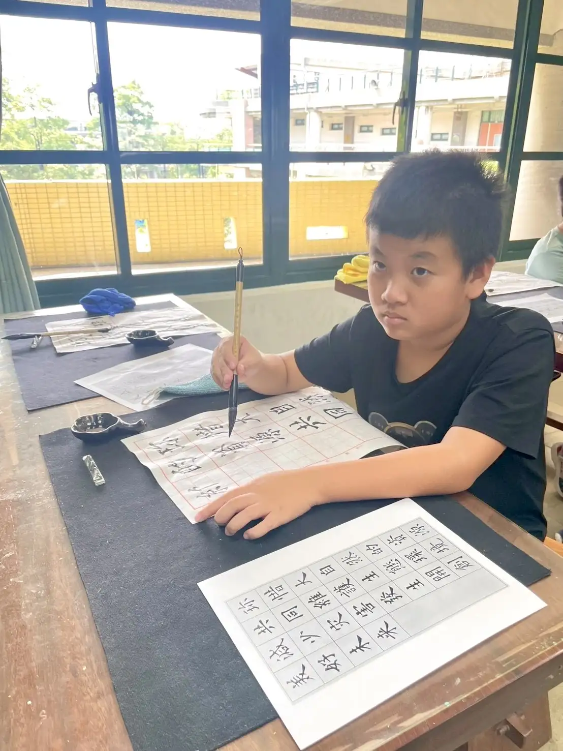 28字臨摹作品整齊展示，校園瞬間被濃濃墨香和新年氣氛包圍。（大寮國小提供）